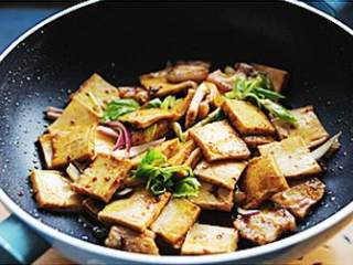 6、干锅千页豆腐,最后关火加入洋葱、小米椒和芹菜,借助余温翻炒均匀即可。