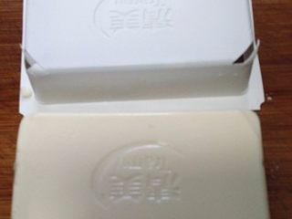 3、火腿豆腐羹,反扣案板上，将四角切小口，就可顺利向上提起包装盒了