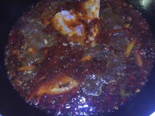 13、美味火锅鱼,开大火烧沸汤料，放入鱼头、盐4勺、鸡精2勺、关小火熬制10分钟，使底料、鱼头的味道充分释放出来。