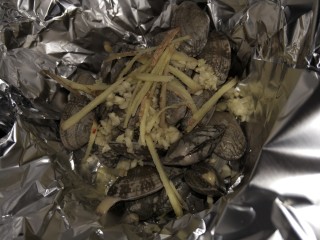 6、锡纸花甲粉,锡纸里放入花甲，蒜末和姜丝