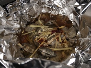 8、锡纸花甲粉,加入调好的酱料中火煮至花甲全开口