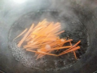 4、韩式石锅拌饭,再将切丝的胡萝卜焯水，锅中加入水，大火烧开，放入胡萝卜丝，1分钟捞出。