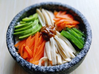 14、韩式石锅拌饭,再放入拌饭酱。(拌饭酱可以根据个人口味放，比如甜面酱，辣酱，肉酱等都可以)