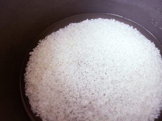 4、金毛肉松卷,把米放进电饭锅，按照米：水为1:1的比例倒进纯净水。或者用食指放在水平面，只要水超出食指的第一个关节就可以。
