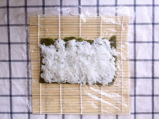 11、金毛肉松卷,在米饭上铺上一层保鲜膜