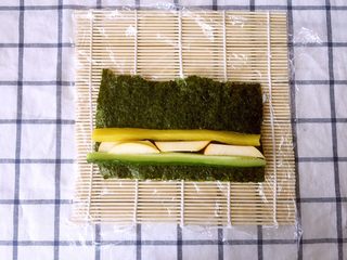 12、金毛肉松卷,翻面后，在靠近自己的一边摆放上黄瓜条、苹果条、大根条