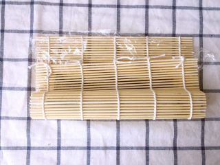 13、金毛肉松卷,帘子向前卷起，注意不要把保鲜膜卷进去了