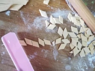 3、一个寿司帘就可以搞定五彩海螺面,再用刀切成宽约1cm的小菱形。