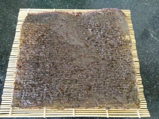 1、黑米寿司,首先准备好一张海苔，放在寿司帘上备用