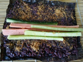 9、黑米寿司,然后将切好的黄瓜和火腿一起放在中间