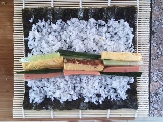 6、自制寿司,把要卷的材料放在中间偏下的位置