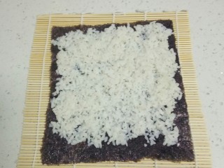 11、家常寿司,寿司卷帘上铺上海带,海带上均匀铺上大米。