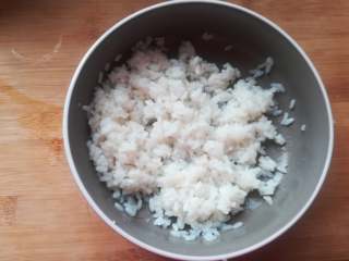 2、紫薯寿司,米饭煮好以后盛到稍大一点的碗里,趁热加入寿司醋拌匀放凉待用。没有寿司醋的,可以按照白醋:糖:盐以6:3:1的比的来调制。