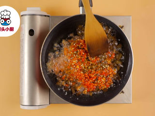 2、自制老干妈辣酱,另起锅倒油250ml烧热，放入炒好的牛肉丁，加入辣椒末100g，小火慢炒10分钟