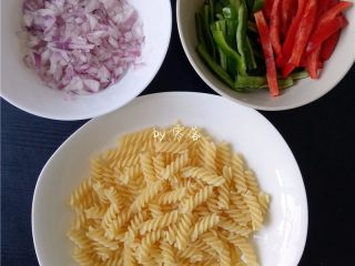 4、双椒螺旋面,螺旋面捞出，沥干水分；洋葱切碎；甜椒、青椒切条；