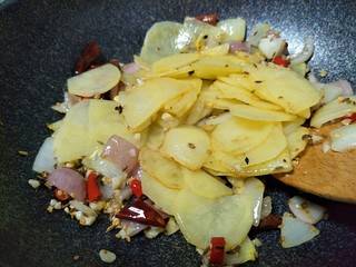 18、家常菜孜然土豆片（超级下饭菜）,当炒出蒜香味，把刚才炒好的土豆倒入。