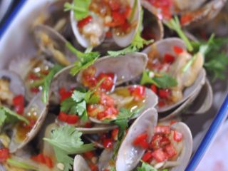 11、蒜蓉蛤蜊,将蛤蜊一个个夹出来放入盘中,浇上酱料。