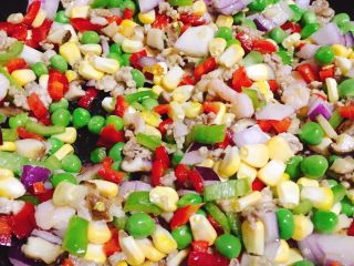 7、海鲜菠萝饭,当肉末，虾仁和鱿鱼快熟的时候把青豆，红辣椒，绿辣椒，洋葱，玉米粒，一起放进去爆炒