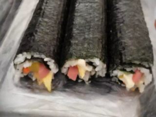 3、招牌寿司,把海苔卷好后，先别松手，让寿司尽量紧一点