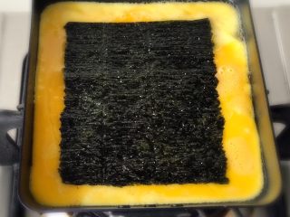 15、青青的素味早餐,等蛋餅差不多都已經凝固，只有上面一層有1/2的濕蛋液時，就可以放海苔片了。