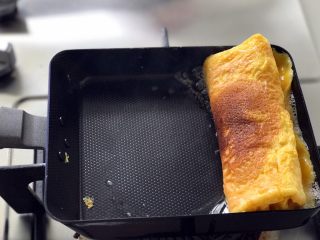 18、青青的素味早餐,同樣，等差不多凝固了，從先前蛋卷的一側卷起，卷好後在鍋里再煎一會兒，讓蛋液充分凝固即可（將收口處朝下封住再煎）。