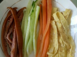 1、简单寿司,把黄瓜，胡萝卜，鸡蛋饼，香肠切成细条。