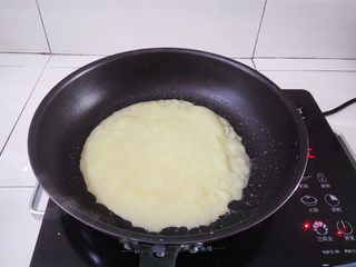 9、紫菜肉松鸡蛋卷,小火加热，面糊凝固到变成蛋饼冒泡的时候用硅胶刮刀铲一下边缘，蛋饼能轻松滑动就可以出锅了（准备一块湿毛巾，煎好蛋饼的的锅放湿毛巾降温，煎出来的