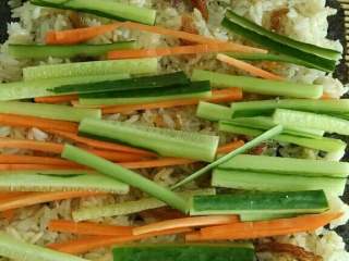 4、豆豉鲮鱼寿司,把豆豉鲮鱼撕碎些均匀摆开，放入黄瓜和胡萝卜丝