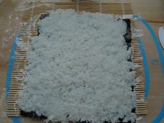 7、里卷寿司,米饭从左自右,从上至下铺好,盖住海苔。