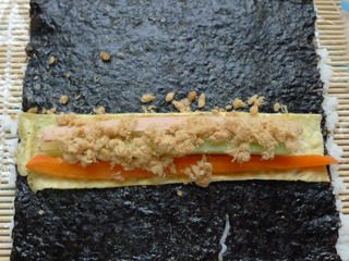 9、里卷寿司,放上喜欢的菜和鸡蛋。撒上少许肉松。