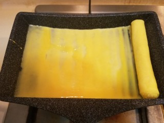 7、樱花玉子烧,把卷好的蛋卷移到锅子左边，再继续煎第二层，按此方法一共卷三层。