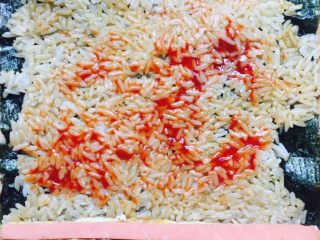 10、家庭简易版寿司????,取一张紫菜，放入适量搅拌好的米饭，依次加入切好的鸡蛋条和香肠条，涂上薄薄的一层番茄酱