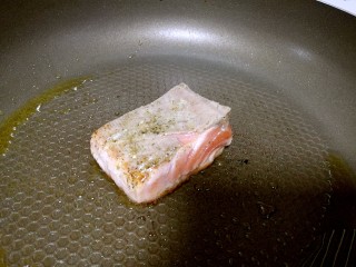 3、塑身益智三文鱼紫菜饭卷,锅中热油，加入姜蒜爆香，将三文鱼放入，改中火煎至两面微黄。