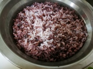 6、塑身益智三文鱼紫菜饭卷,出门前，将黑米白米洗净，水米比例1:1，并加入几滴油，放入定时高压锅中设定好时间，晚上到家，米粒颗颗晶莹的杂粮米饭已经炖好了。将杂粮米饭到入炒好的杂蔬三文鱼中拌匀。
