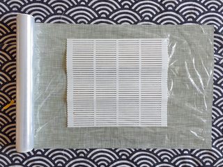 4、早餐物语｜中国版寿司——粢饭团,将卷帘平铺在桌上，上面再铺一层保鲜膜；