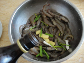 3、油爆虾,先用料酒，葱段和生姜片把虾腌制20分钟去腥