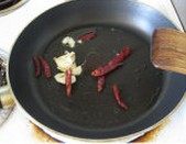 2、彩椒酱爆鸡丁,热油，加入蒜瓣、干辣椒煸炒出味