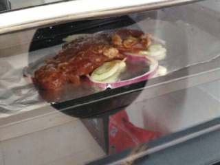 3、≈酱香烤肉≈,接着在烤盘里铺上锡纸，再放上，洋葱，大蒜，大葱，生姜在底部，接着放入腌制好的肉