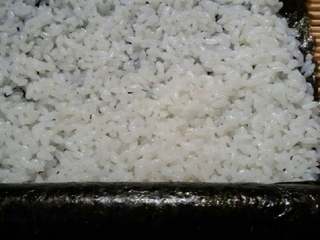 1、四方寿司卷,香肠用紫菜包好，封口。另取一张紫菜，铺上饭，放上刚用紫菜包好的香肠，卷成圆柱形。