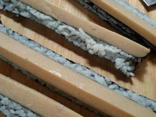 2、四方寿司卷,把卷好的卷切成相等4份。