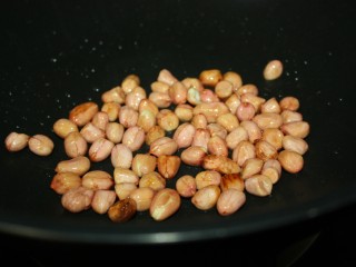 7、美味下饭宫保豆腐,花生洗净晾干，热锅冷油放入花生米，铺开，小火慢炸，不断翻动，听到噼里啪啦的声音基本停止时即关火，盛出备用。