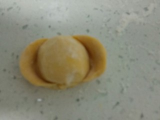 13、南瓜花样小馒头,取一个剂子，排气后，用手团圆，再搓成长条，两端约留1寸，用拇指在两端分别压扁，再从两端往中间推，两边捏紧。