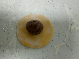 14、南瓜花样小馒头,取一个剂子，排气后，用手团圆，再擀成薄片，取20克红豆沙团圆后放在中间。