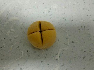 15、南瓜花样小馒头,收口后，光滑的一面朝上，用刀在中间分别垂直交叉切2刀。