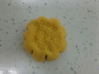 17、南瓜花样小馒头,收口后，光滑的一面朝上，用手压扁，两边用刮刀均匀往里推，再用吸管在上面按出圆圈。