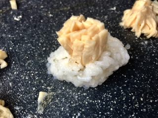 15、金菊西米寿司,将寿司饭中间稍微捏进去一些，然后将卷好的蛋皮插上去，这样能够稍微固定下底部。然后用筷子小心拨开一条一条蛋皮。
