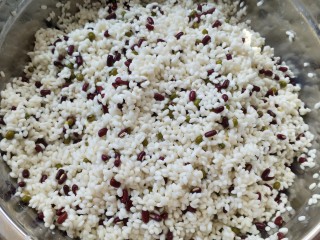 5、不同类型粽子的包法,把苏打水慢慢淋到米里，边淋边搅拌（在这里说一嘴，粮食里加碱，营养成分是会破坏的，大家不好这口还是不要加碱的好），慢慢糯米会变黄。