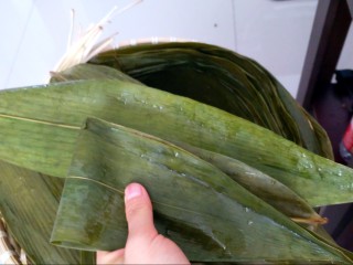8、不同类型粽子的包法,再拿一张或两张粽叶，把前两张对折好的粽叶的一面包住。