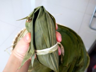 15、不同类型粽子的包法,开始收口了，把粽叶捋顺，全部对折过来。用绳子绑紧。