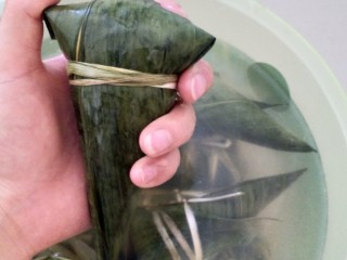 29、不同类型粽子的包法,用绳子绑住最后叶子对折的地方，包子不漏米。三角粽子也就包好了。